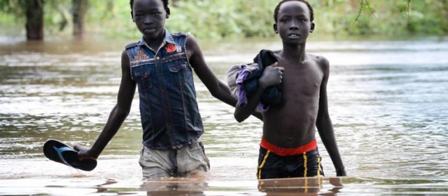Two boys pick their way along a flooded road in Maban county, South Sudan. © UNHCR/Elizabeth Stuart
