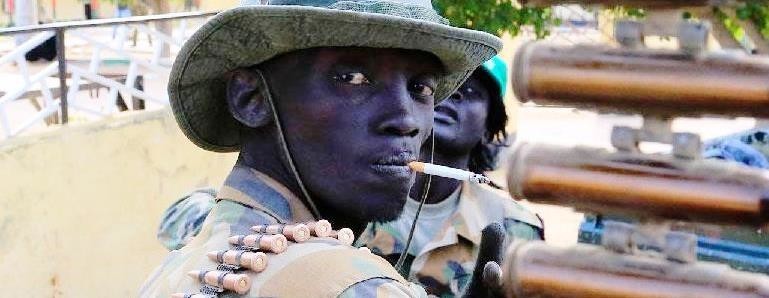 A South Sudanese soldier stands next to a machine gun mounted on a truck (File photo)