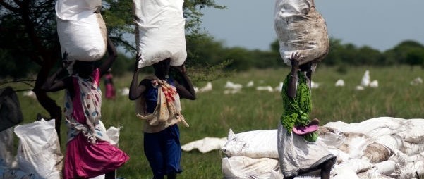 Women carry sacks of food, airdropped by the World Food Programme and distributed by the NGO Oxfam on July 3, 2017 in Padding, Jonglei. (Credit: ALBERT GONZALEZ FARRAN/AFP via Getty Images)