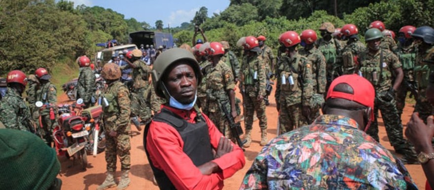 Ugandan musician-turned-politician Robert Kyagulanyi (C), also known as Bobi Wine, stands on a road in the middle of a forest as his electoral campaign was blocked by Uganda People's Defence Forces (UPDF) in Kalangala district, Central Uganda, on December 30, 2020. PHOTO/AFP.