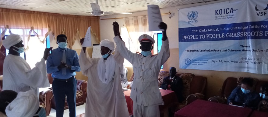 Dinka Malual paramount chief Dut Majak (L), Rizeigat Omda Mohammed Banani (R) unveil the signed resolutions before the peace delegates at South Sudan Hotel in Nyamlel, Aweil West County on 18 June, 2021.[Photo: Radio Tamazuj]
