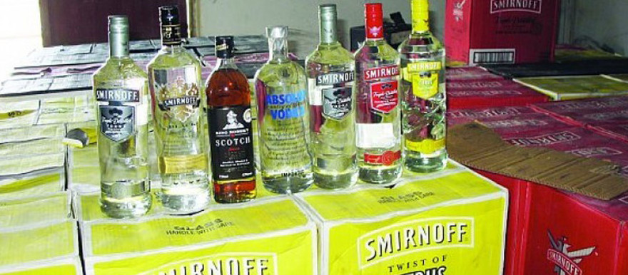 Eastern Equatoria State trade minister, Ruth Marius Buga posing with some of the banned alcoholic brands. File photo