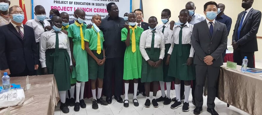 Chinese Ambassador to South Sudan Hua Ning, South Sudan's Vice President for Service Cluster Hussein Abdelbaggi Akol, and students pose for a photo during the 2nd education project launch in Juba on 6 Dec 2021. [Photo: Radio Tamazuj]
