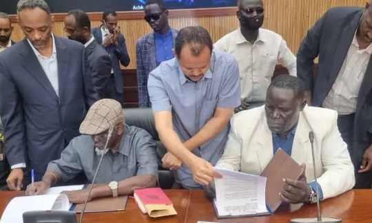 Gen. Gatwech (L) and Olony (R) inking the peace deal. (Courtesy photo)