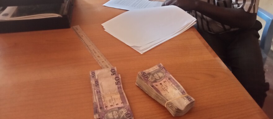 A cashier at Northern Bahr el Ghazal State finance ministry disbursing salaries on 25 January 2022. [Photo: Radio Tamazuj]