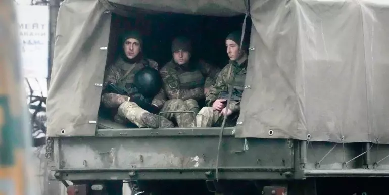 Ukrainian soldiers ride in a military vehicle in Mariupol, Ukraine [Photo: Sergei Grits/AP Photo]