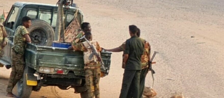Soldiers of the Sudanese army stand near their vehicle on a road blocked with bricks in Khartoum on May 20, 2023. © AFP