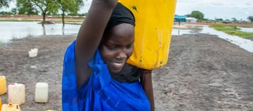 A returnee carries a jerrycan from a water point at a transit centre in Rubkona Count in Unity State. (Credit: OCHA)
