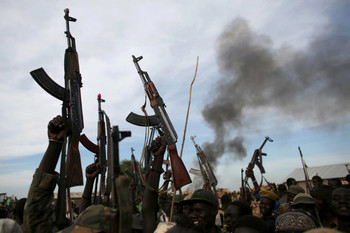 File photo: Rebel fighters hold up their rifles as they walk in front of a bushfire in a rebel-controlled territory in Upper Nile State in 2014. (REUTERS)