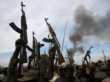 File photo: Rebel fighters hold up their rifles as they walk in front of a bushfire in a rebel-controlled territory in Upper Nile State, South Sudan February 13, 2014. /REUTERS