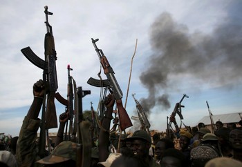 File photo: Rebel fighters hold up their rifles as they walk in front of a bushfire in a rebel-controlled territory in Upper Nile State. (Reuters)