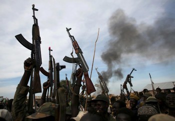 File photo: Rebel fighters hold up their rifles as they walk in front of a bushfire in a rebel-controlled territory in Upper Nile State in 2014. (REUTERS)