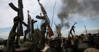 File photo: Rebel fighters hold up their rifles as they walk in front of a bushfire in a rebel-controlled territory in Upper Nile state, South Sudan Feb. 13, 2014.