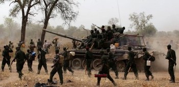 File photo South Sudanese soldiers walk alongside a tank as they withdraw from the town of Jau, at the disputed border with Sudan March 17, 2013/ Reuters.