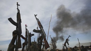Photo: Rebel fighters hold up their rifles as they walk in front of a bushfire in a rebel controlled territory in Upper Nile State, South Sudan, Feb. 13, 2014.(Reuters)