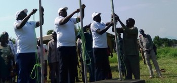 Officials at the launch of the new university (from left to right) Pierre Atilio , vice chancellor of the university, Tobiolo Alberio, Torit State Governor and Vitale Ongejuk, State Minister of Education raising the flags of the Equatoria International University on  21June, 2019 (Radio Tamazuj)