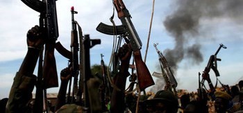 Photo: Rebel fighters hold up their rifles as they walk in front of a bushfire in a rebel-controlled territory in Upper Nile state, South Sudan Feb. 13, 2014.(Reuters)