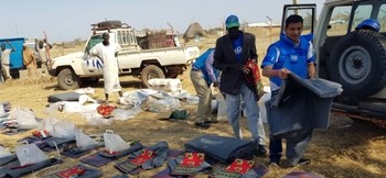 IOM staff in South Sudan prepare clothing and household items for distribution to survivors of the January 22 attack on the town of Kolom. © IOM 2020