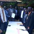 Photo: Representatives of the Yei government and the opposition group during the signing of the peace deal in Kampala on May 31, 2017. (Radio Tamazuj)