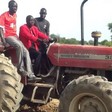 File photo: Commissioner Santo Amuol (middle) driving a tractor during the inauguration of the youth farm. (Radio Tamazuj)