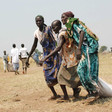File photo: South Sudanese women drag bags of grain to a central collection point dropped by WFP (IRIN)
