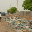 People walk by garbage disposed of on the side of the road in Juba. (Courtesy photo)